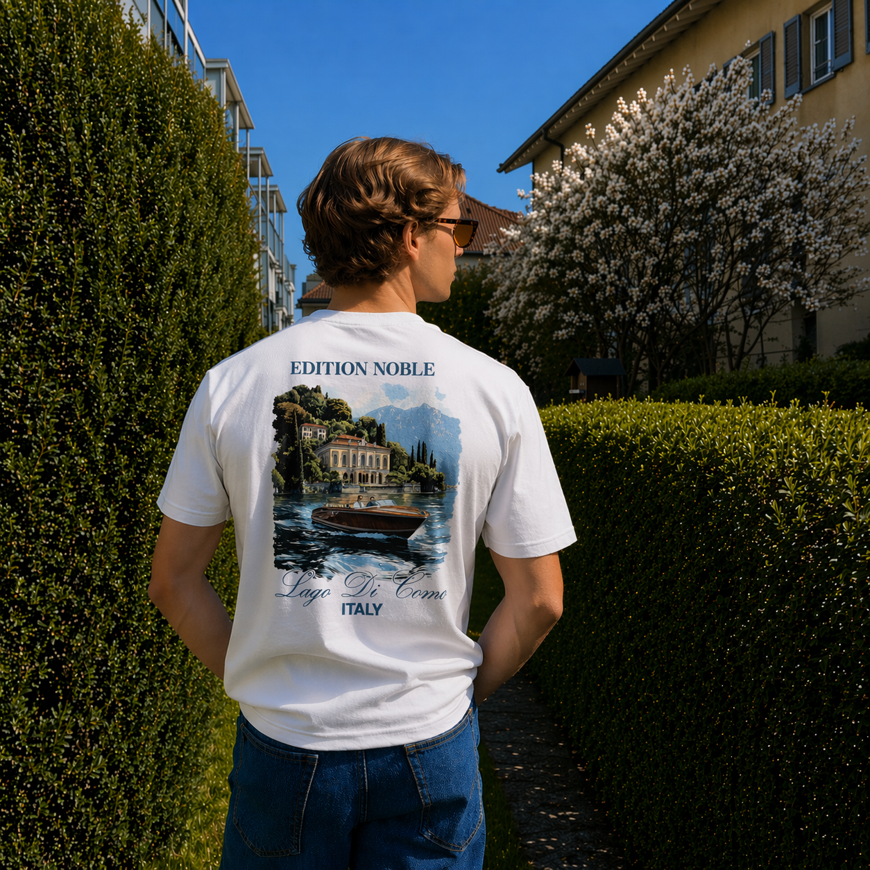 Person wearing a white t-shirt with a scenic design and text, standing outdoors.